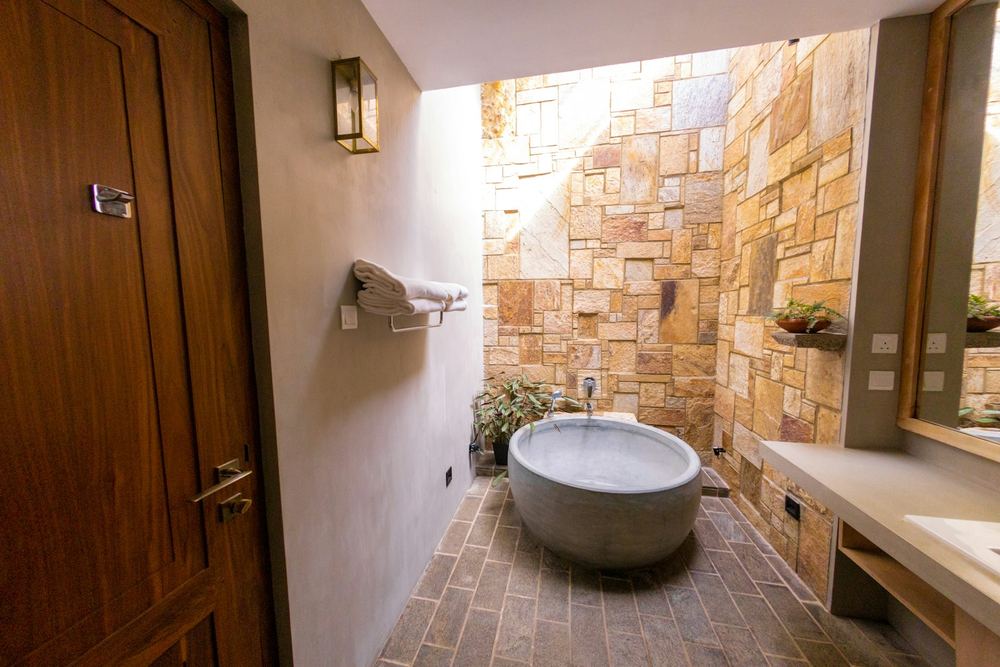 A round stone bathtub in an open air bathroom.