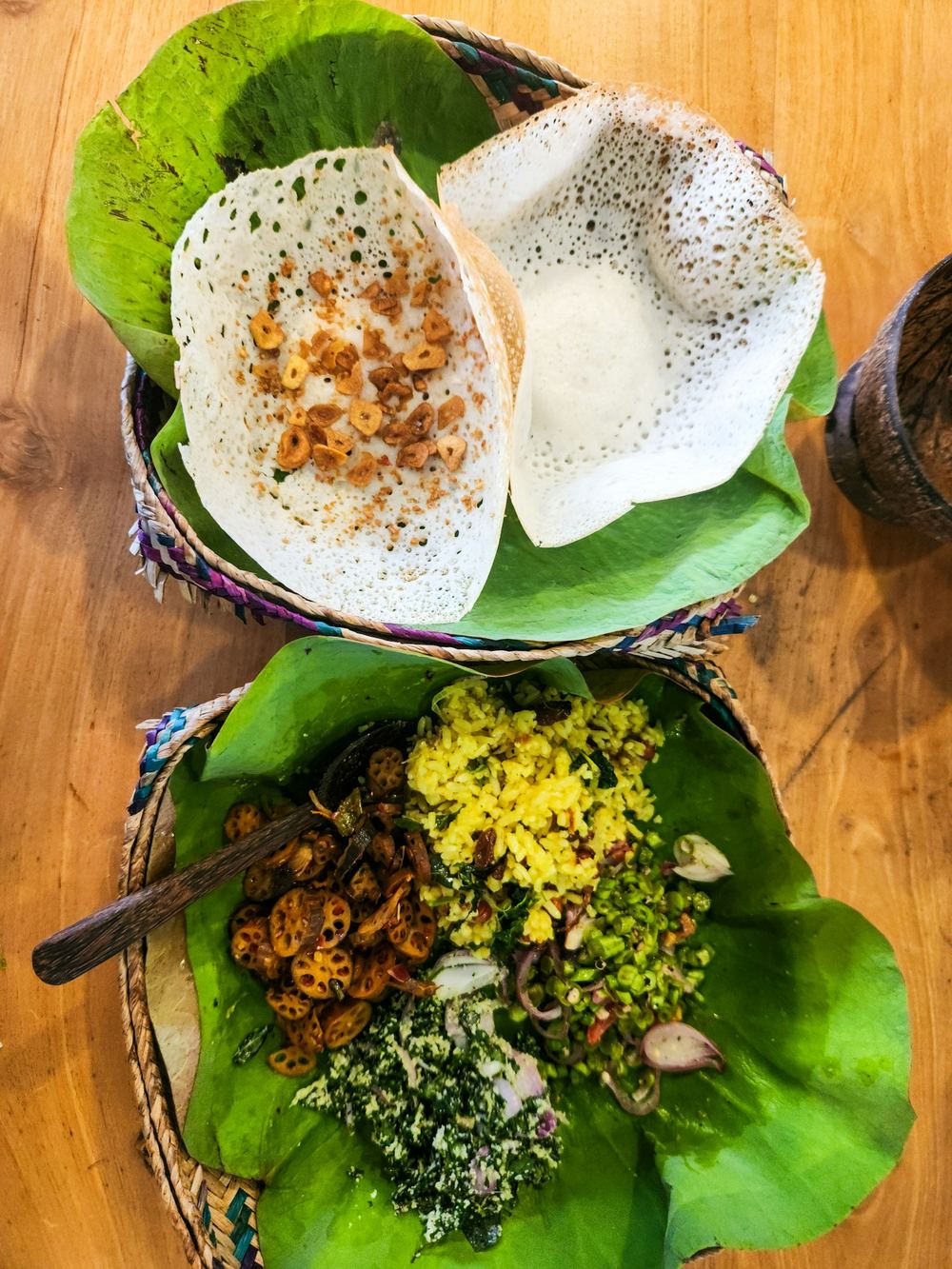 String hoppers, coconut sambol and curries on banana leaves.