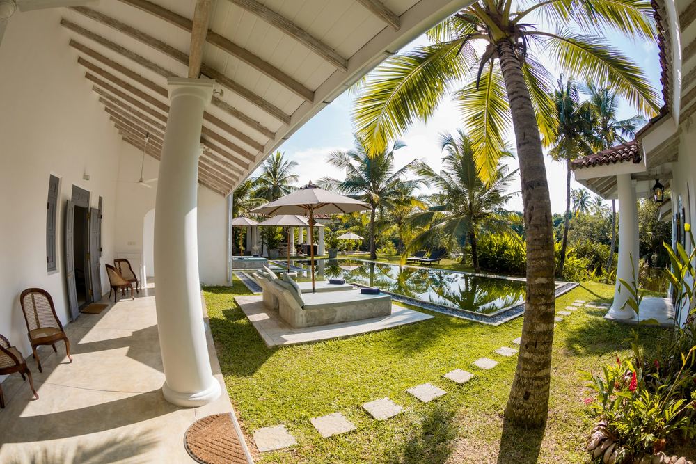 A colonial veranda with white columns above the pool.