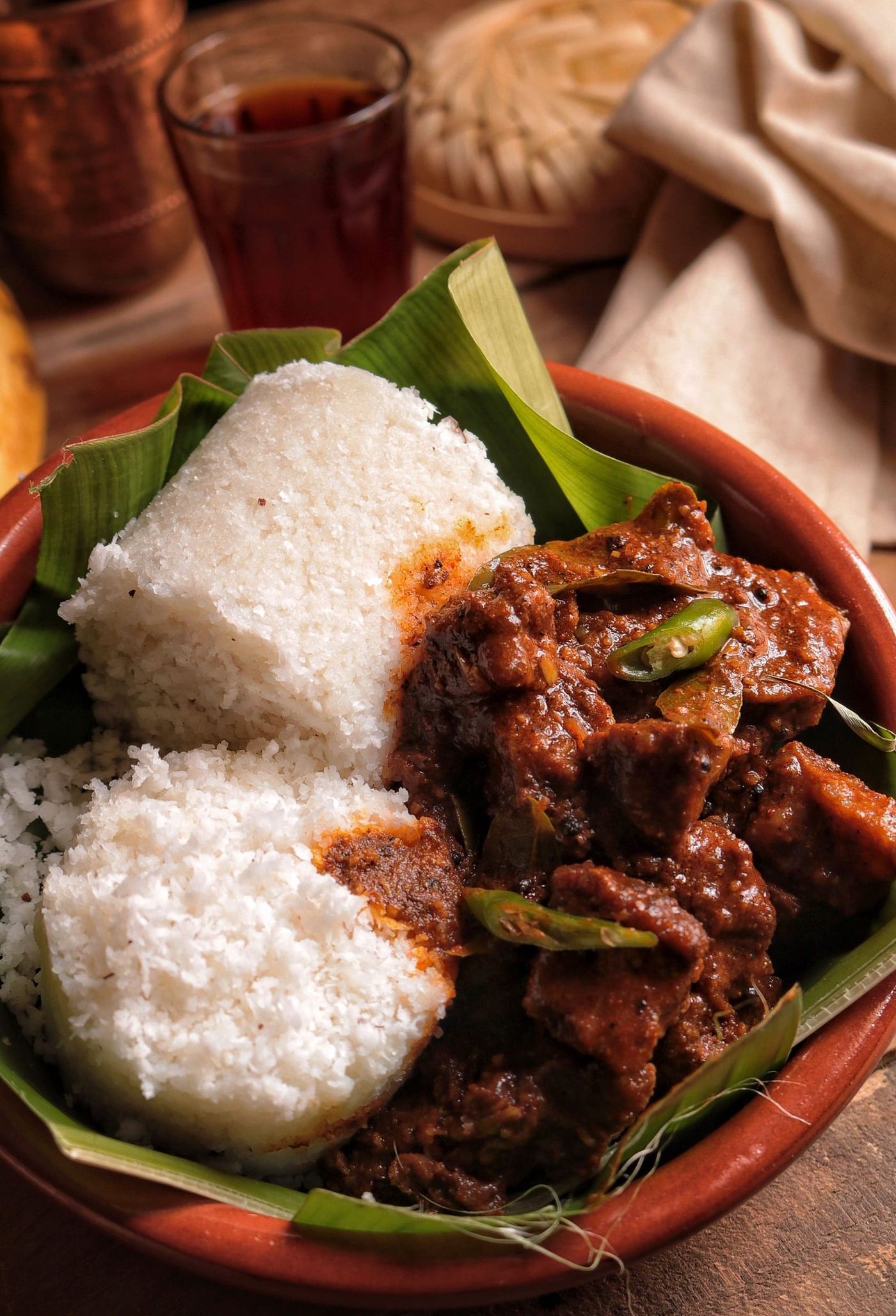 Steamed rice and a dark curry served on a banana leaf.