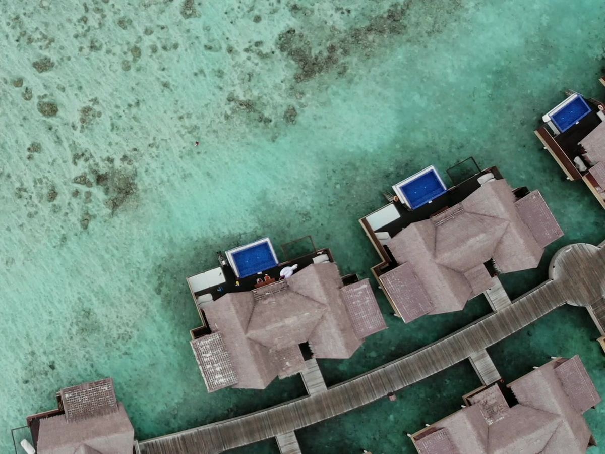 Muhudu: water villas with private pools on a boardwalk over the reef, seen from above.