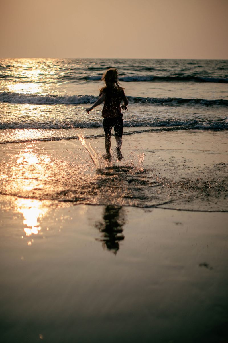 Feet splashing through shallow water, the low sun on the wet sand.